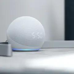 Alexa para casa, un altavoz inteligente blanco con pantalla LED que muestra la hora, iluminado por una luz azul.