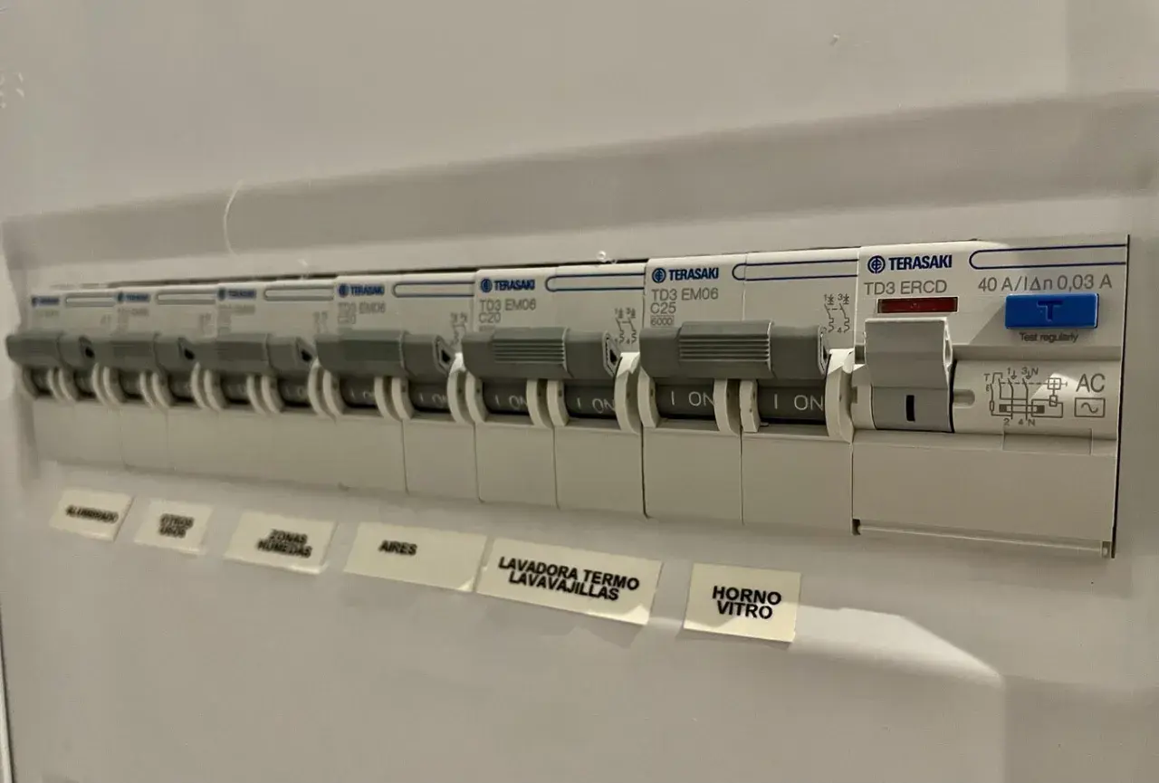 Panel eléctrico con varios interruptores automáticos. Uno indica "40 A", útil para saber cuántos amperios son 2000w en tu instalación.